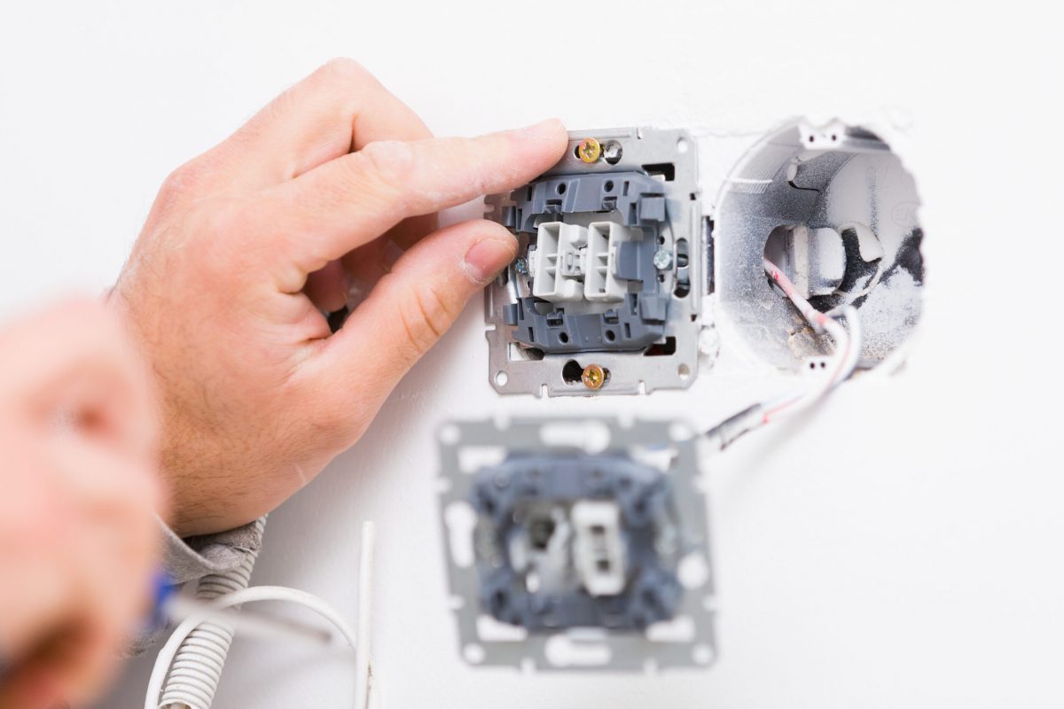 Electrcian,Hands,Installing,Light,Socket,Into,The,Wall.