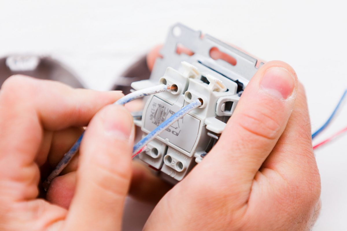 Electrcian,Hands,Installing,Light,Socket,Into,The,Wall.